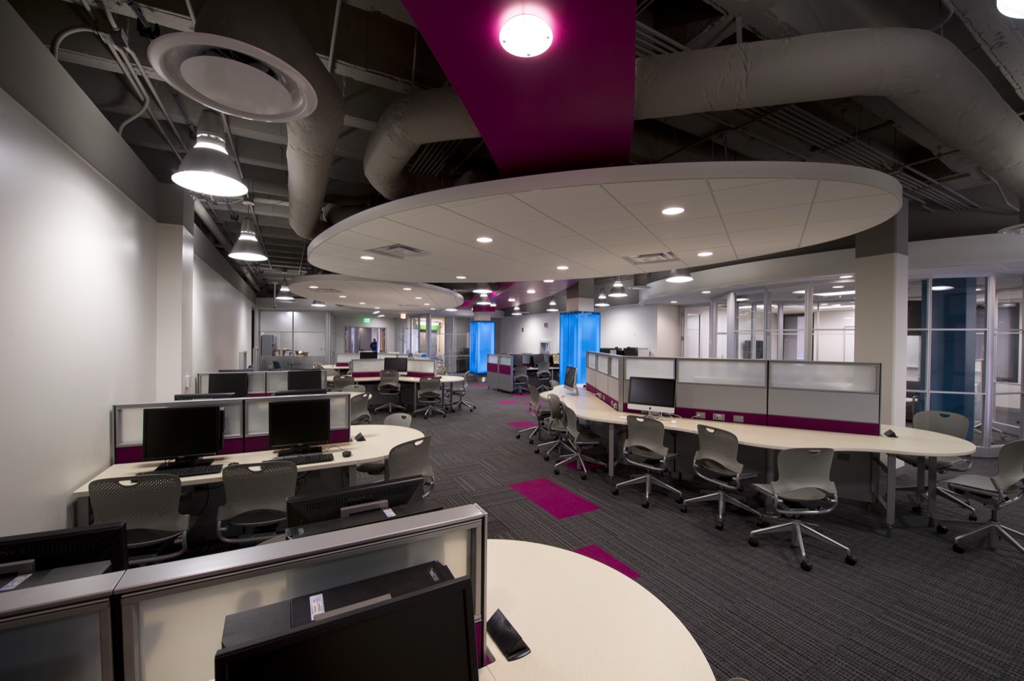 A computer lab in Tech Commons: curved rows of desks with monitors and task chairs under round ceiling panels.